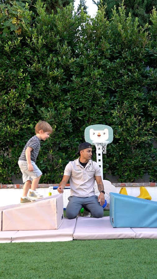 An LA Sports World coach supporting a child during an activity
