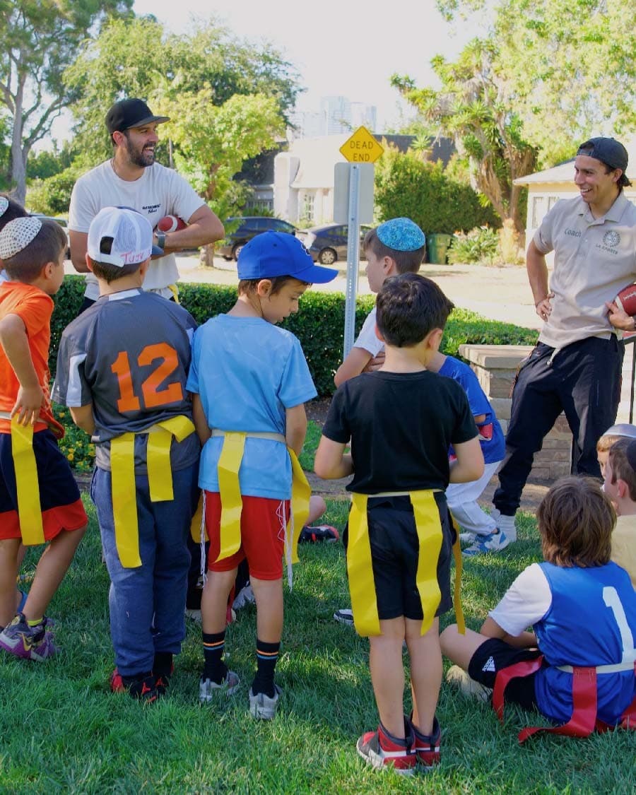 Children gathered with LA Sports World coaches for an outdoor group session