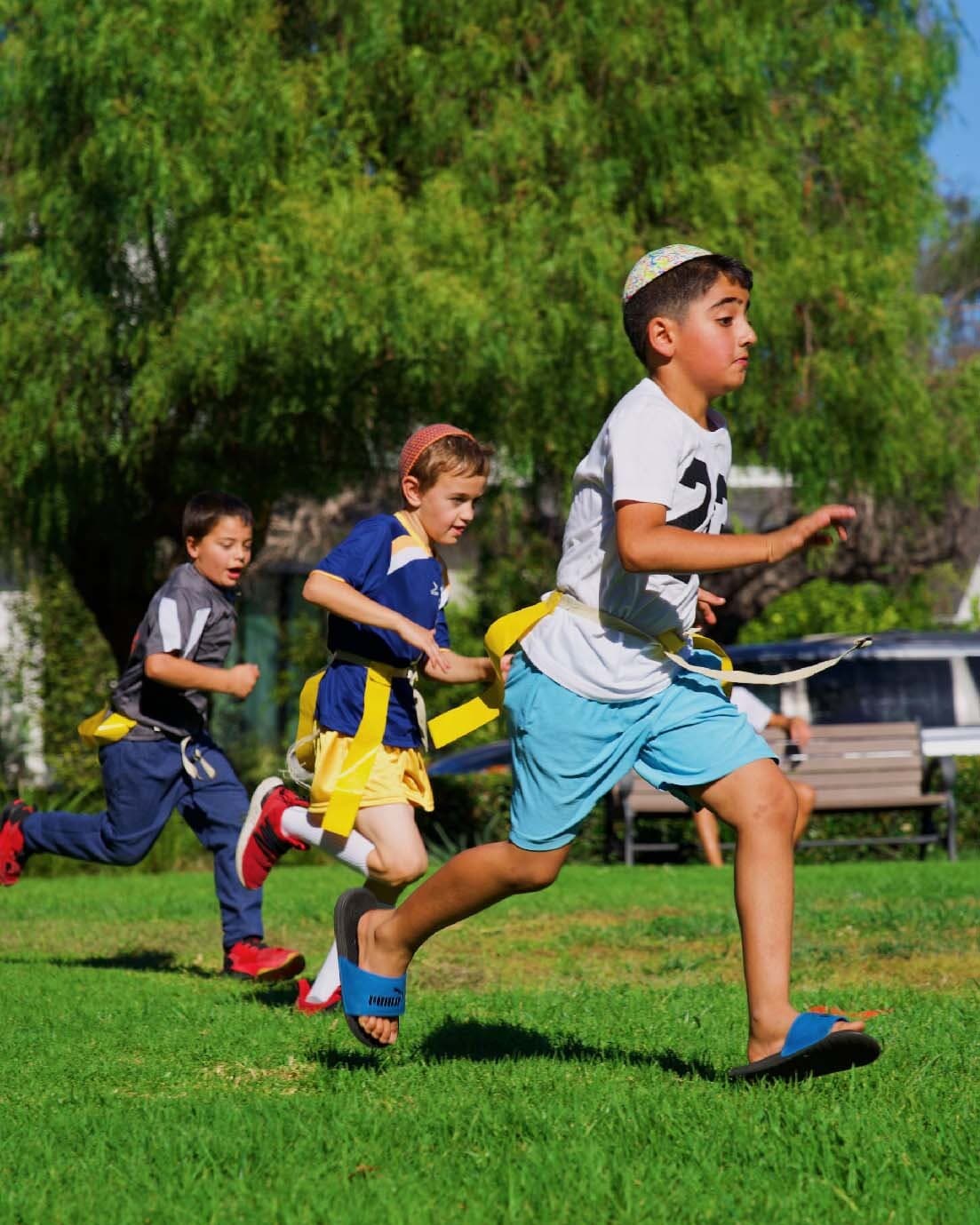 Children running during an outdoor flag football game